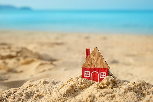 little red house on a sandy beach