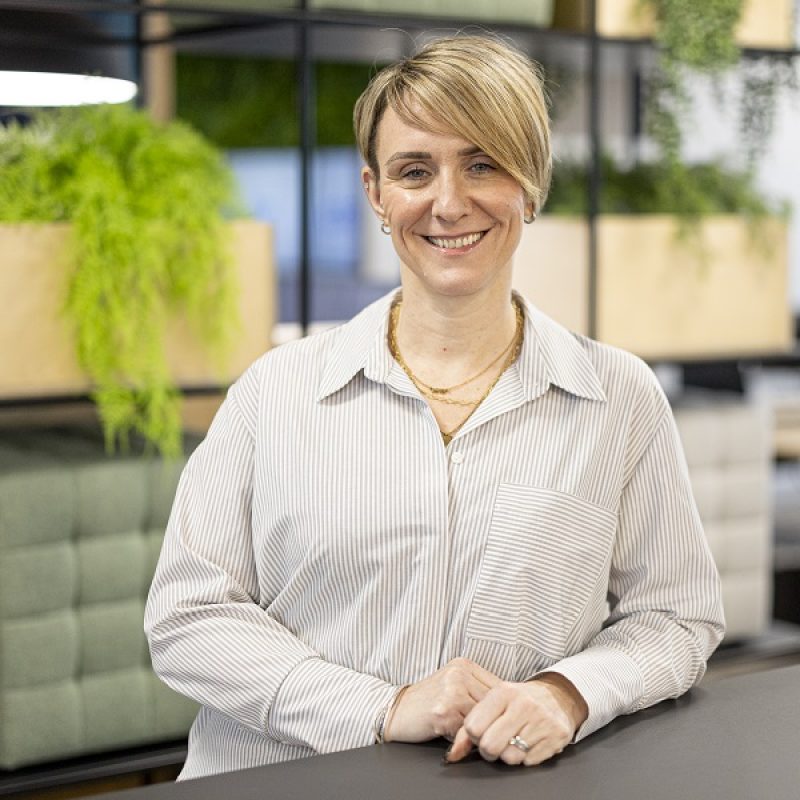 Marketing Director Claire Hextall leaning on a desk smiling