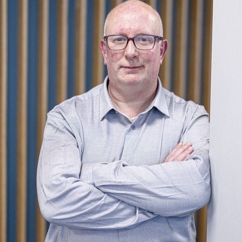 David Rainford leaning against wall smiling